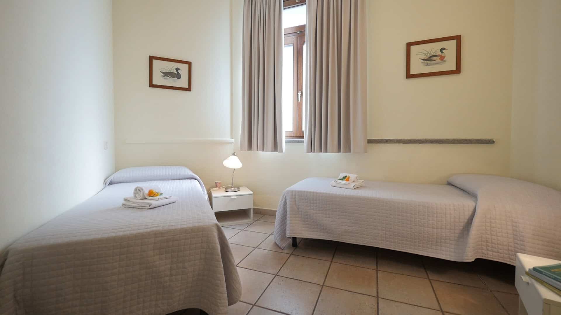 camera con due letti e finestra luminosa